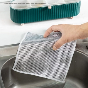 Macro shot of silver metal wire mesh cleaning cloth used on a stainless steel sink surface