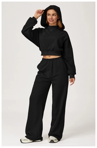 Detail of high-waist wide-leg joggers set with cropped hoodie in premium black fabric
