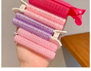 Set of colorful plastic hair rollers and styling clips for volumizing roots and bangs