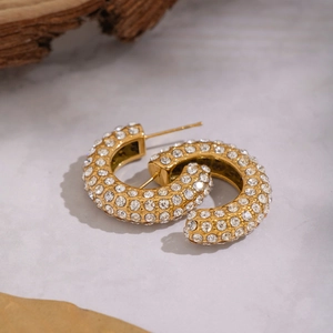 Boucles d'oreilles C plaquées or 18K avec strass sur fond en marbre élégant
