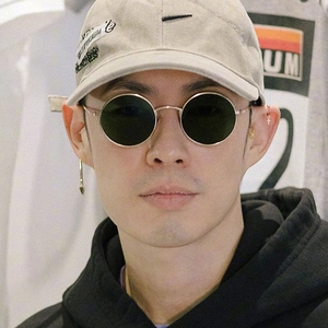 Vue de face de lunettes de soleil rondes rétro portées avec une casquette de baseball beige en coton