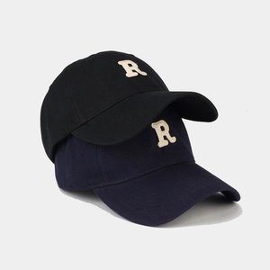Dettaglio dei cappellini da baseball in cotone con logo R ricamato in nero e blu navy