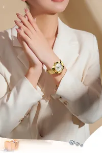 Close-up of elegant gold stainless steel watch with white dial on a woman's wrist