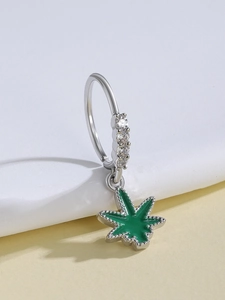 Close-up of silver ring earring featuring white zircons and a green enamel leaf charm