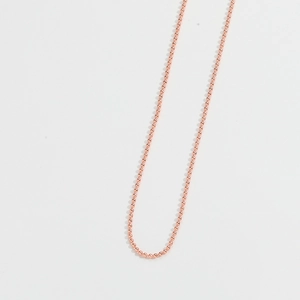 Nahaufnahme der roségoldenen Kugelkette mit polierter, glatter Metalloberfläche