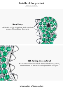 Gros plan des boucles d'oreilles dinosaure en argent 925 avec zircons verts pavés