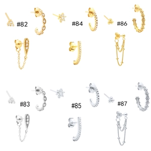 Macro detail of gold and silver flower earrings set featuring zircon studs and chain cuffs