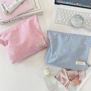 Detail view of pink and blue cosmetic bags with silver star sequins and brand tag