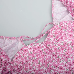 Close-up of pink floral dress featuring thin straps and pleated neckline detail