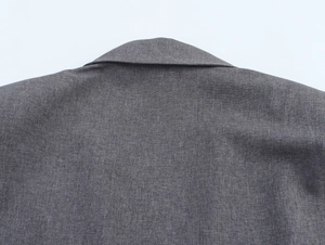 Detailed macro view of gray blazer neckline and woven fabric texture on white background