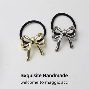 Detailed view of high-gloss gold and silver metallic bow hair ties with black elastic bands