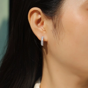 Close-up of elegant double-row moissanite hoop earrings worn by a model in silver finish