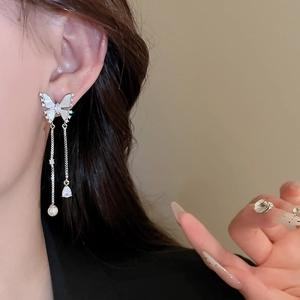 Detail of silver butterfly tassel earrings with white shell wings and zircon stones