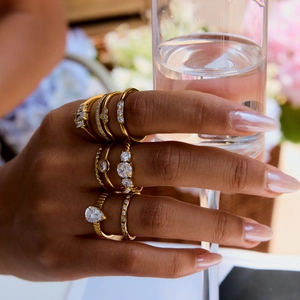 Close-up of gold titanium rings set with zircon worn by a model in a cozy scene