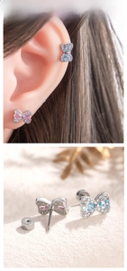 Detail of bow-shaped titanium earrings featuring pear-cut stones and secure screw-back design