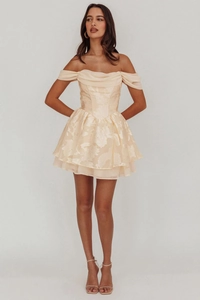 Close-up of champagne floral jacquard fabric and layered ruffle skirt on a mini dress