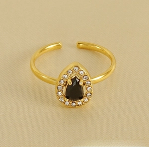 Détail macro de bague ajustable dorée avec zircon noir en goutte et halo de diamants