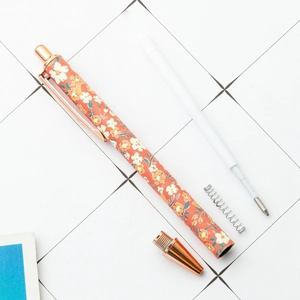 Floral retractable ballpoint pen with rose gold trim and internal spring components
