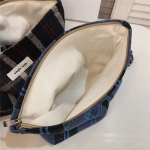 Detail of plaid cosmetic bags showing interior lining, metal zipper and woven label