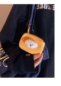 Detail of orange plush puppy coin purse with white poodle design and blue hook