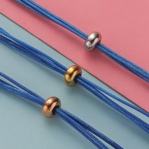 Detail of metal beads in gold, silver and rose gold on blue braided cord bracelets