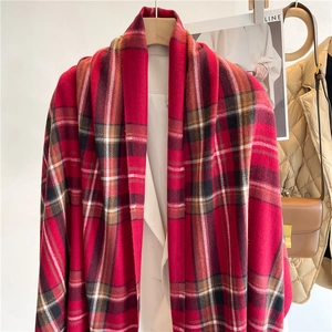 Dettaglio della sciarpa in cashmere rossa con trama a quadri classica e frange