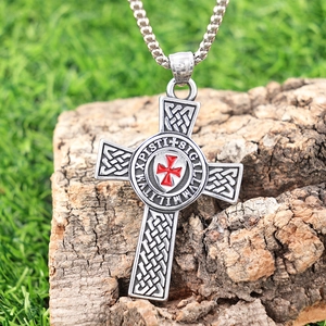Vintage silver Maltese cross pendant necklace with red enamel on a rustic wood background