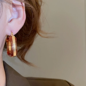 Detail of vintage square resin drop earring with amber marble pattern on model
