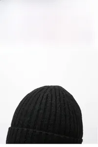 Detail van zwarte gebreide muts met verticale ribbeltextuur en warme thermische voering