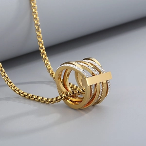 Close-up of multilayer gold-plated interlocking rings pendant with sparkling rhinestones