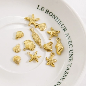Polished gold stainless steel ocean pendants featuring various starfish and seashell shapes