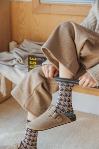 Detailed view of autumn houndstooth socks paired with stylish brown buckle mule shoes