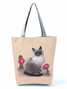 Detailed view of the Siamese cat and pink cactus flower illustration on the beige tote bag