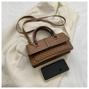 Brown leather handbag with logo pattern shown next to a smartphone for size reference