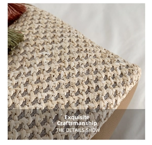 Close-up of woven straw bucket bag with red and green tassels showing texture