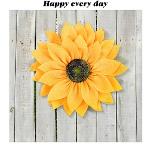 Detail of yellow mesh sunflower wreath on grey wood fence with Happy Every Day text