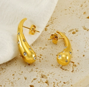 Macro shot of 18K gold drop earrings with micro-set white cubic zirconia on stone base
