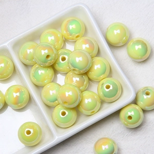 Macro view of pearlescent yellow-green acrylic round beads with high luster and center holes