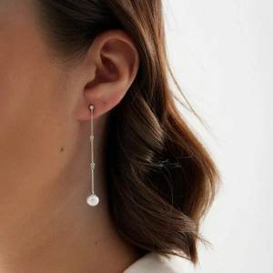 Detail of s925 silver long tassel earrings with lustrous pearls and cubic zirconia stones