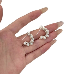 Elegant C-shaped silver stud earrings with pearls and micro-pave crystals on white background