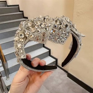 Detail eines silbernen Strass-Haarreifens mit Schleife und schwarzem Samtfutter