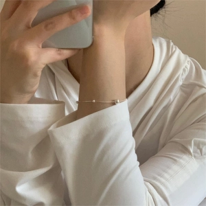 Detailed close-up of a minimalist S925 sterling silver bead snake chain bracelet on wrist