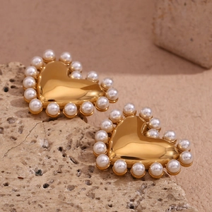 Detail of 18K gold heart stud earrings with white pearl border on a stone