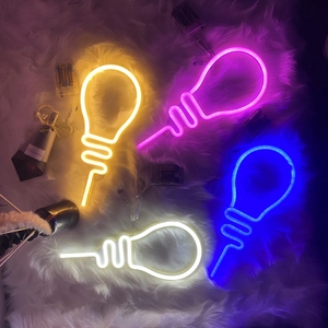 Bulb-shaped LED neon lights in warm yellow and blue on white plush carpet