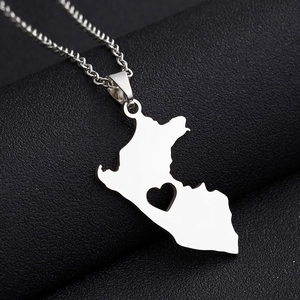Vista macro del ciondolo mappa del Perù in acciaio argento con cuore ritagliato su pelle