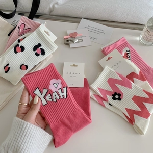 Mid-calf cotton socks in pink and white with heart, leopard print, and letter patterns