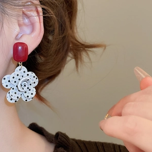 Detailed view of vintage resin polka dot flower tassel earrings worn by a model