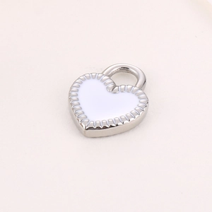 Macro detail of a heart-shaped silver pendant with white enamel finish for jewelry making