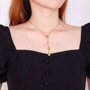 Elegant gold Y-shaped stainless steel necklace featuring three polished gradient beads
