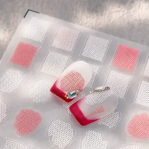 Macro view of red and white grid nail stickers featuring rhinestones and bead accents